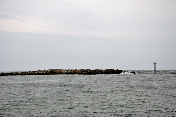 The waves were breaking high over the nearby jetty